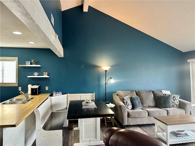 living room with lofted ceiling with beams, dark hardwood / wood-style flooring, and sink