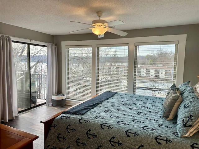 bedroom featuring hardwood / wood-style flooring, ceiling fan, a textured ceiling, and access to outside