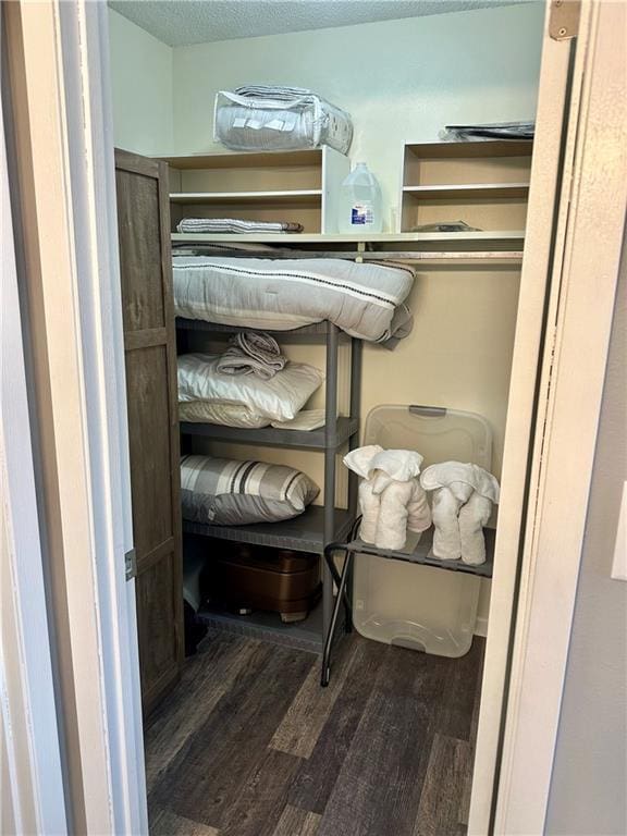 walk in closet with dark wood-type flooring