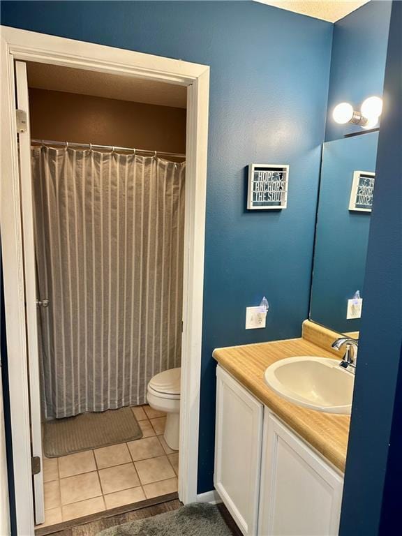 bathroom with curtained shower, tile patterned flooring, vanity, and toilet