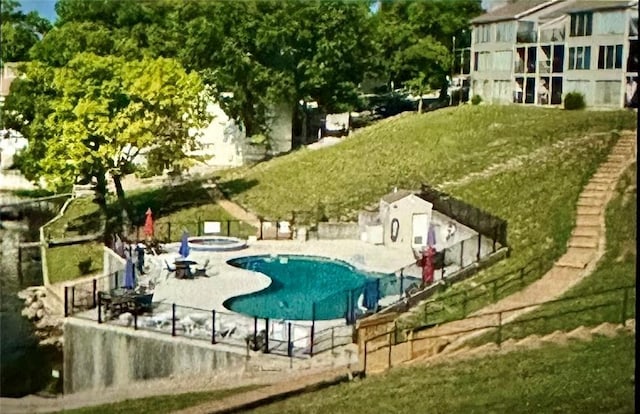 view of pool with an in ground hot tub, a patio area, and a lawn