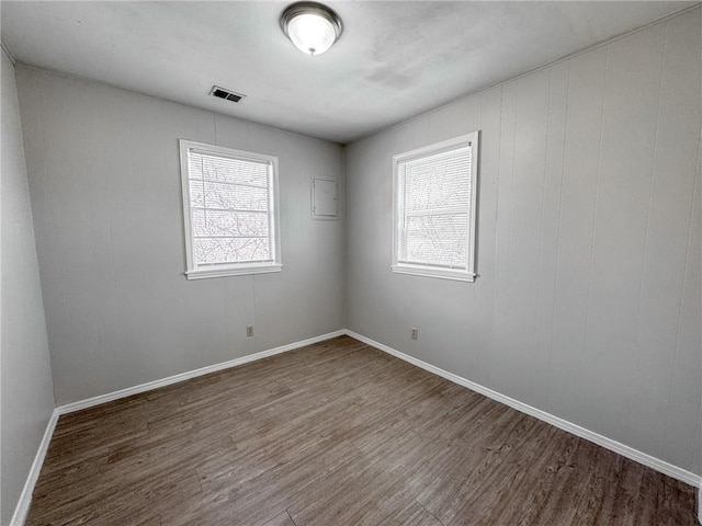 empty room with a wealth of natural light and wood-type flooring