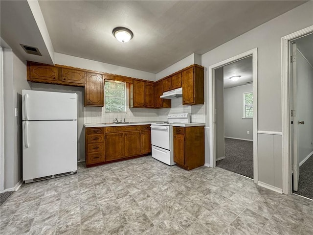 kitchen with white appliances, sink, and tasteful backsplash