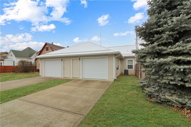 ranch-style home featuring a garage, a front lawn, and central air condition unit