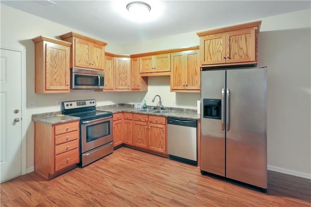 kitchen with sink, light hardwood / wood-style floors, and appliances with stainless steel finishes