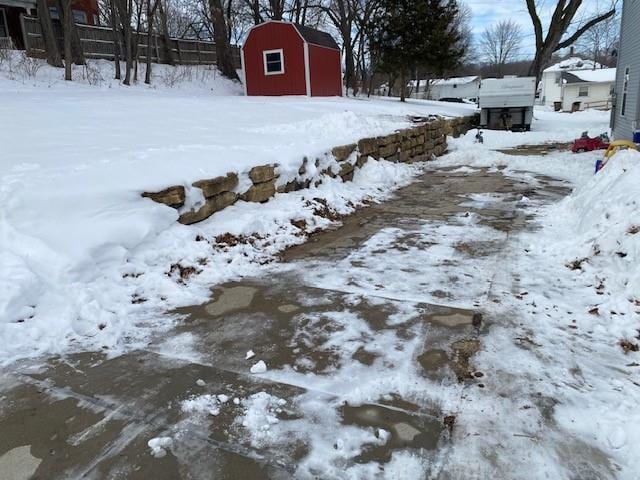 yard covered in snow with a storage unit