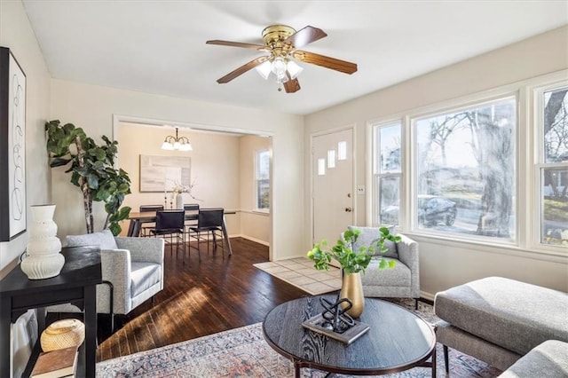 living room featuring ceiling fan with notable chandelier and dark hardwood / wood-style floors