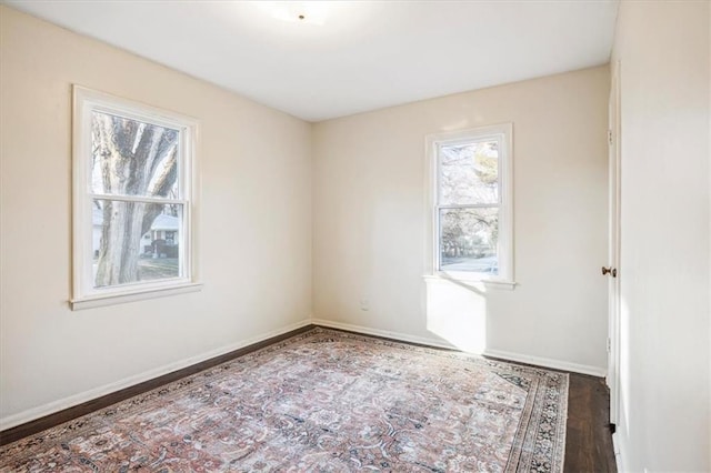 unfurnished room with dark wood-type flooring