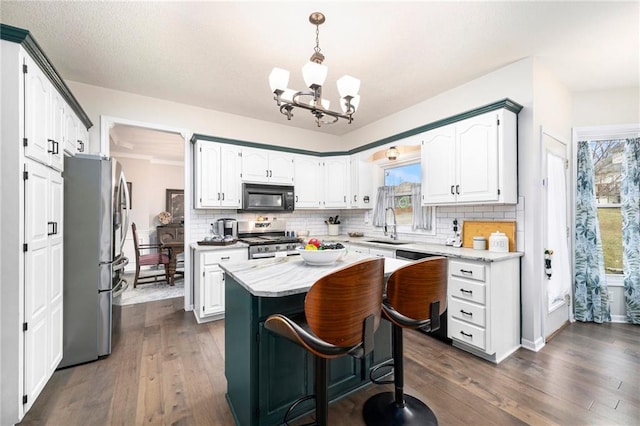 kitchen with white cabinetry, decorative backsplash, stainless steel appliances, and a kitchen island