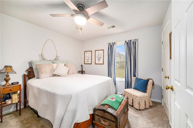 carpeted bedroom featuring ceiling fan and a textured ceiling