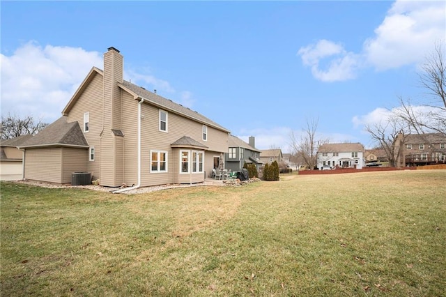 back of house with central AC and a lawn