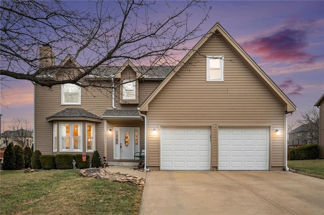 front of property with a garage and a yard