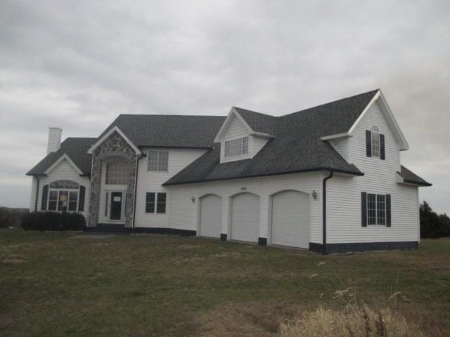 view of front of home with a front lawn and a garage