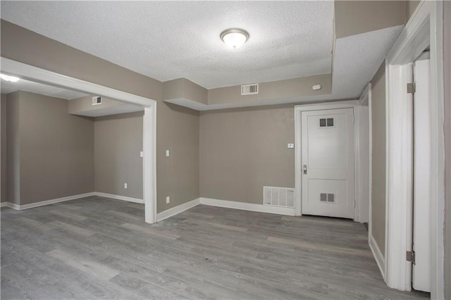 interior space featuring a textured ceiling and light wood-type flooring