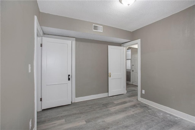 unfurnished bedroom with light hardwood / wood-style floors and a textured ceiling