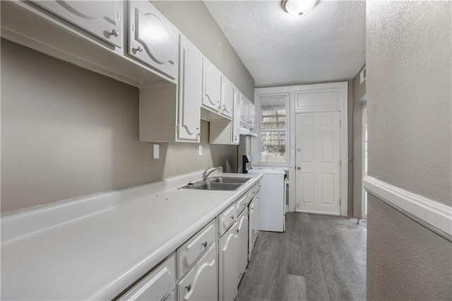 kitchen with white cabinets, a textured ceiling, dark hardwood / wood-style flooring, and sink