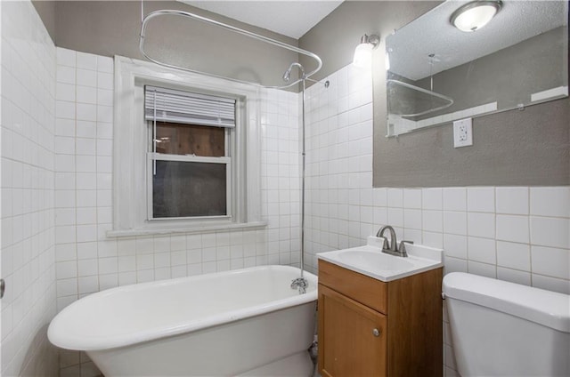 full bathroom with tile walls, a textured ceiling, toilet, vanity, and bathtub / shower combination