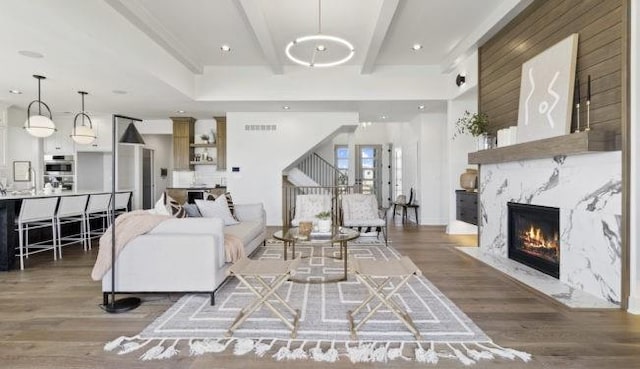16905 Parkhill St, Overland Park, KS 66221 - living area featuring wood finished floors, a high end fireplace, beam ceiling, and stairs