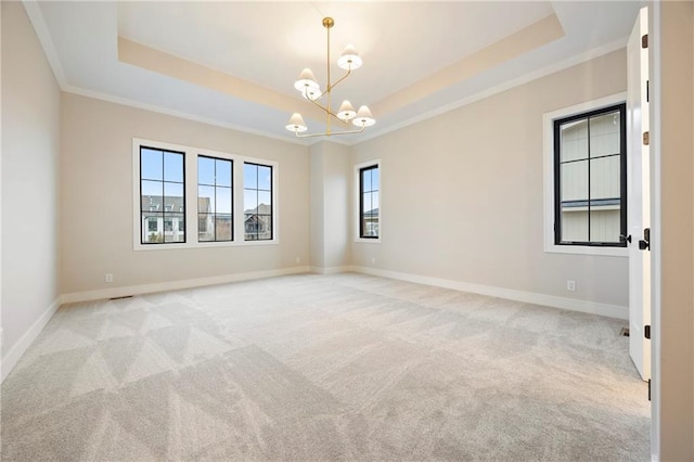 unfurnished room featuring light carpet, an inviting chandelier, baseboards, and a tray ceiling