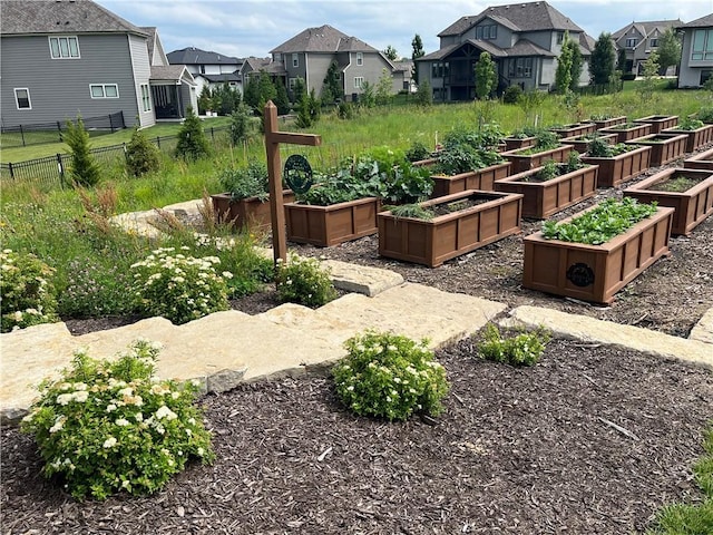 view of yard featuring a garden, fence, and a residential view