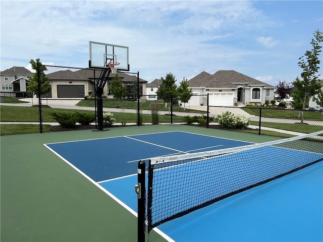 view of basketball court featuring a residential view, community basketball court, and fence