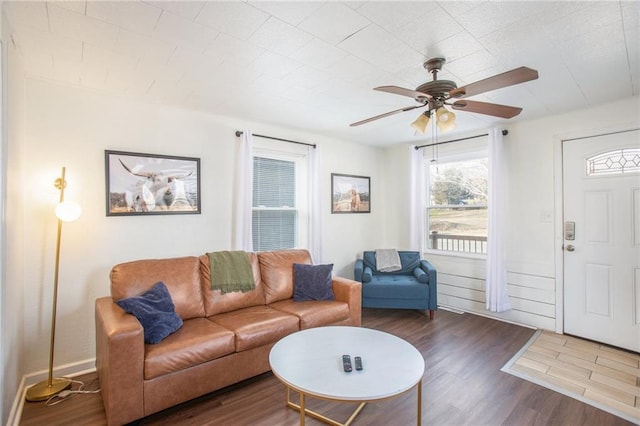 living room featuring ceiling fan and dark wood-type flooring