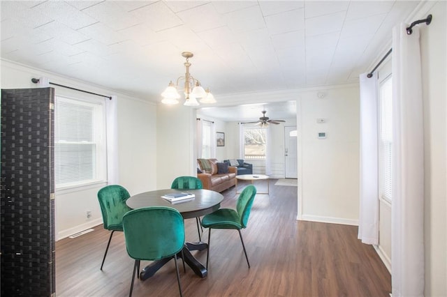 dining room featuring ceiling fan with notable chandelier, ornamental molding, and dark wood-type flooring