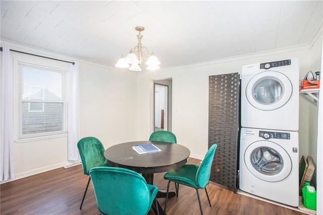 dining area with crown molding, dark wood-type flooring, stacked washer and dryer, and a chandelier