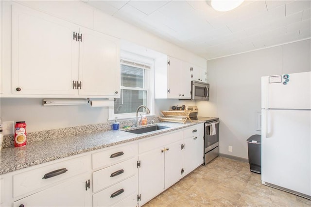 kitchen featuring light stone counters, sink, white cabinets, and stainless steel appliances