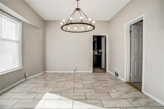 unfurnished dining area featuring a chandelier