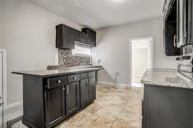 kitchen with decorative backsplash, range, sink, and dark stone countertops