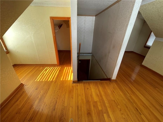 bonus room featuring light hardwood / wood-style flooring and a textured ceiling