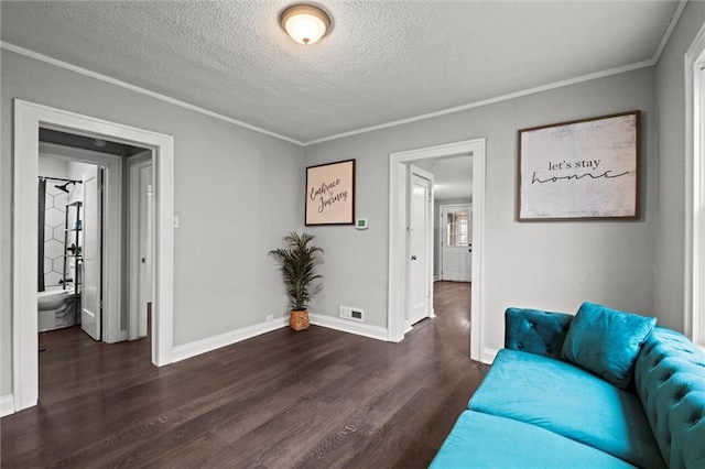 living room featuring dark hardwood / wood-style flooring, a textured ceiling, and ornamental molding