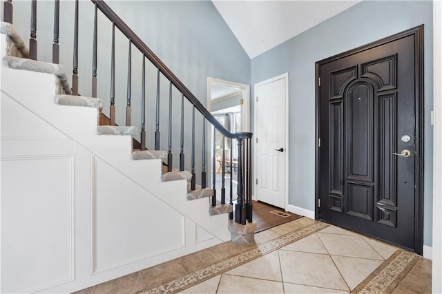 tiled entryway with vaulted ceiling