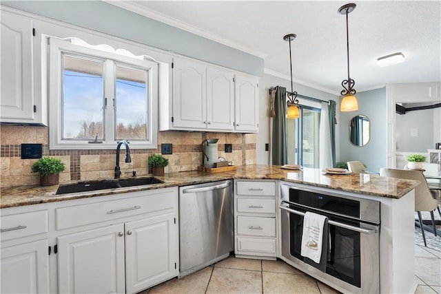 kitchen featuring light stone countertops, white cabinetry, sink, stainless steel appliances, and kitchen peninsula