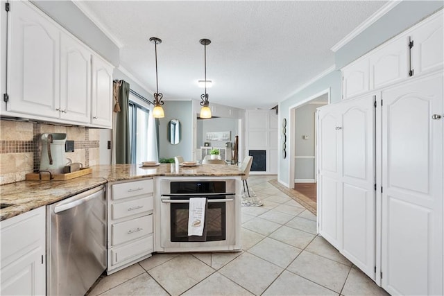 kitchen with light stone counters, stainless steel appliances, pendant lighting, light tile patterned floors, and white cabinets