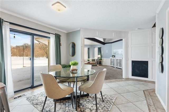 tiled dining space featuring crown molding and a textured ceiling