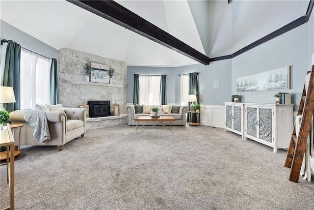 living room featuring carpet floors, high vaulted ceiling, and a stone fireplace