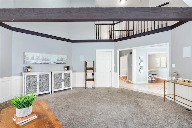 living room with light colored carpet and a high ceiling