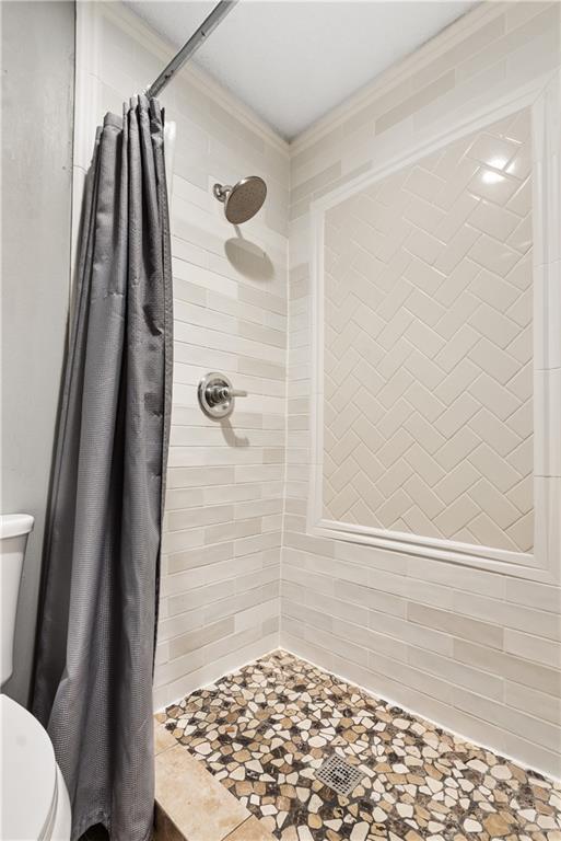 bathroom with a shower with curtain and toilet