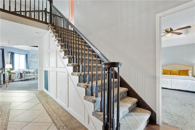 stairs with carpet flooring and ceiling fan