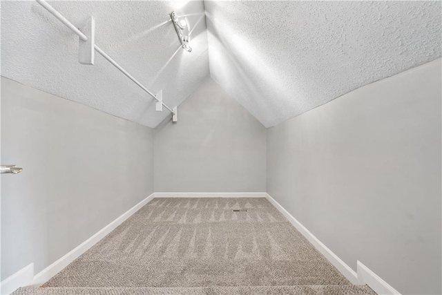 walk in closet featuring carpet flooring and vaulted ceiling