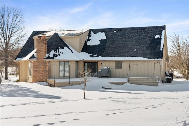 view of snow covered back of property