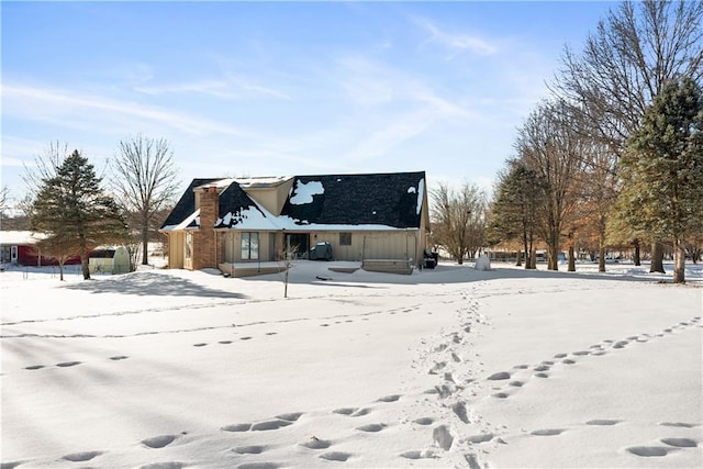 view of snow covered rear of property