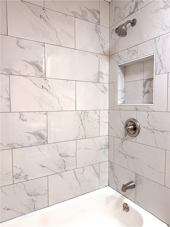 bathroom with tiled shower / bath combo