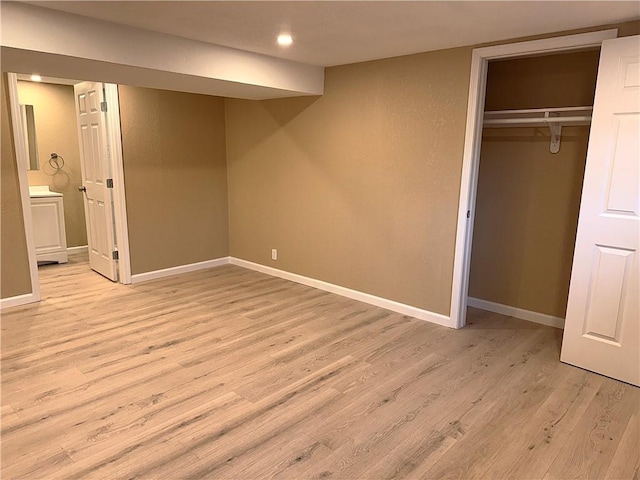 unfurnished bedroom with light wood-type flooring and a closet