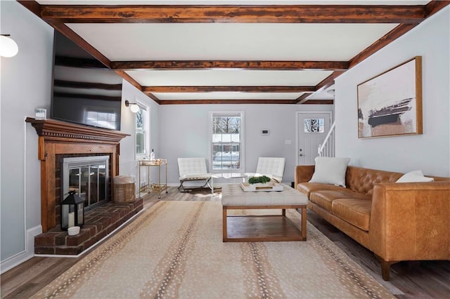 living room featuring a brick fireplace, hardwood / wood-style flooring, and beam ceiling