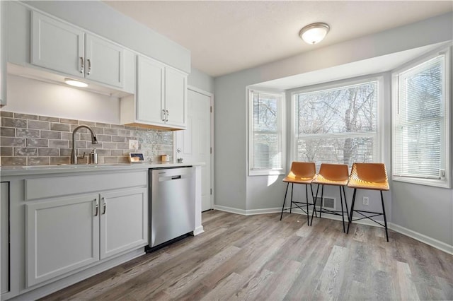 kitchen featuring sink, stainless steel dishwasher, and white cabinetry