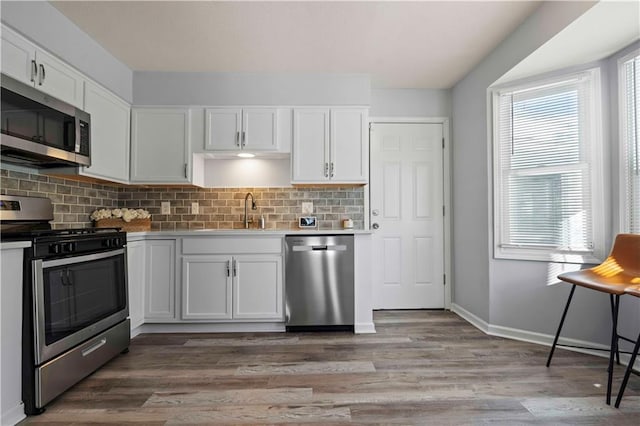 kitchen featuring stainless steel appliances, white cabinetry, and sink