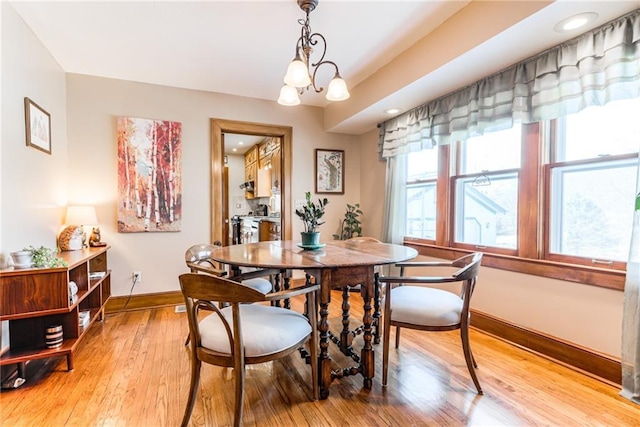 dining space with a chandelier and light hardwood / wood-style flooring